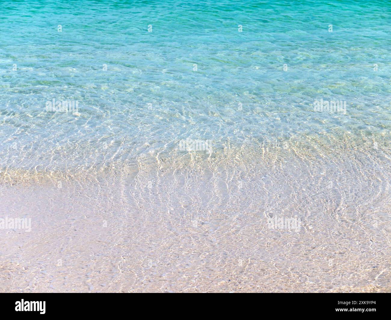 Sfondo dall'estetica cristallina dell'acqua di mare turchese. Isola Paradiso. Spiaggia sabbiosa bagnata dall'onda. La destinazione per le vacanze estive dei sogni. Foto Stock