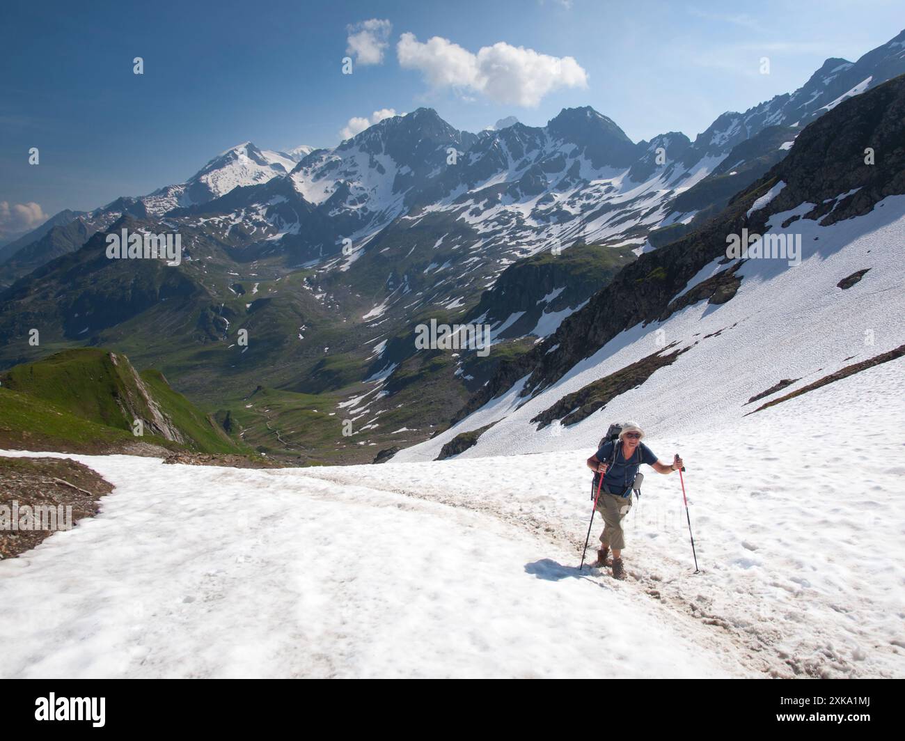 Una donna anziana cammina sulla neve lungo il tragitto verso il col du Bonhomme tra Les Contamines e Les Glaciers durante il Tour du Mont Blanc. Foto Stock