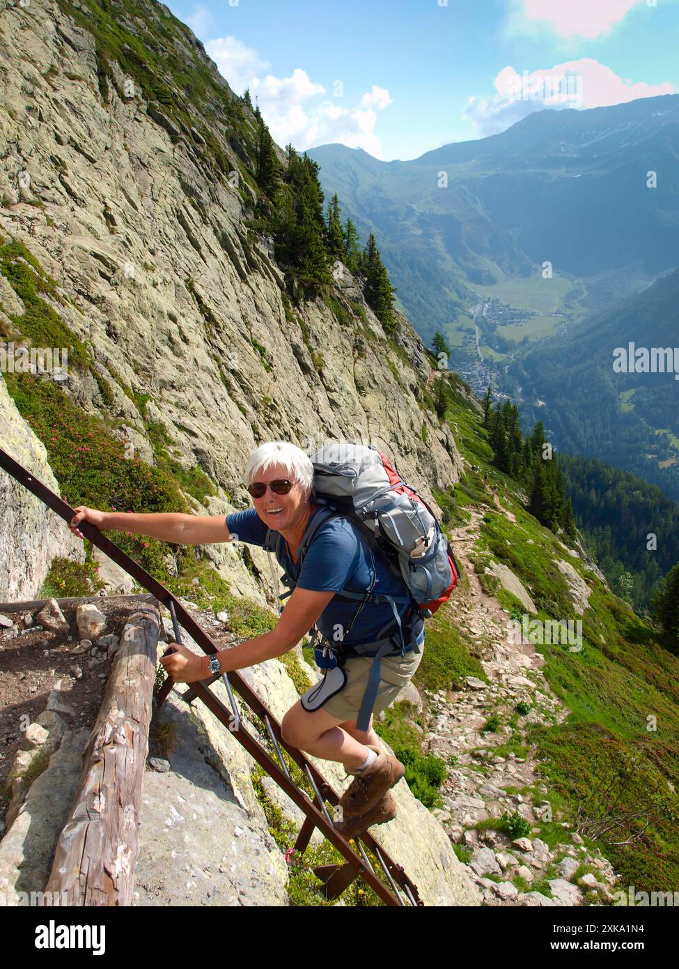 Un'anziana signora che arrampica le scale vicino a Lac Blanc nell'Aiguilles Rouges tra Argentiere en Chamonix nel Parco Nazionale Aiguilles Rouges. Foto Stock