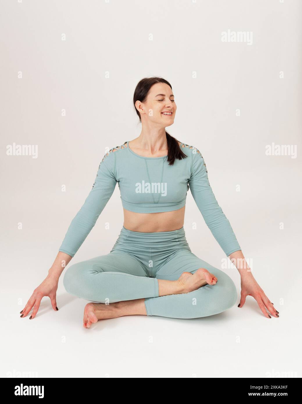 Giovane donna che pratica l'asana su uno studio di sfondo bianco. Foto Stock