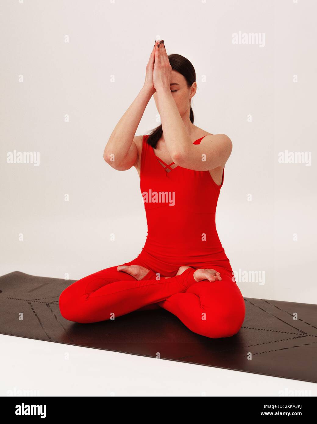 Giovane donna che pratica l'asana su uno studio di sfondo bianco. Foto Stock