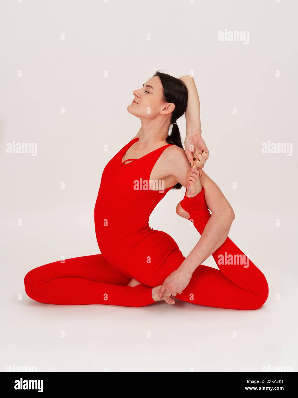 Giovane donna che pratica l'asana su uno studio di sfondo bianco. Foto Stock