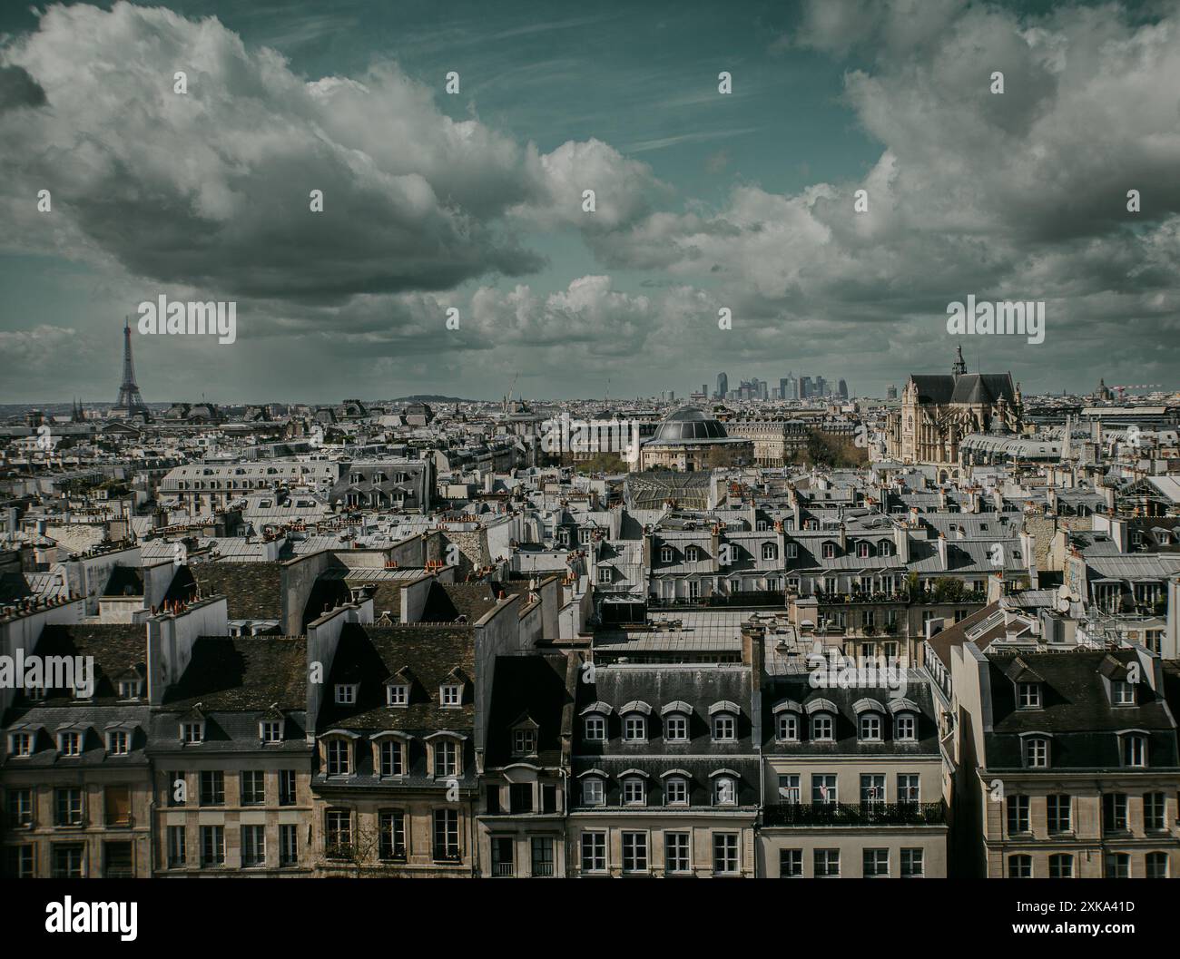 ville de Paris avec vue sur les toits des habitations et la tour Eiffel au loin par temps nuageux Foto Stock