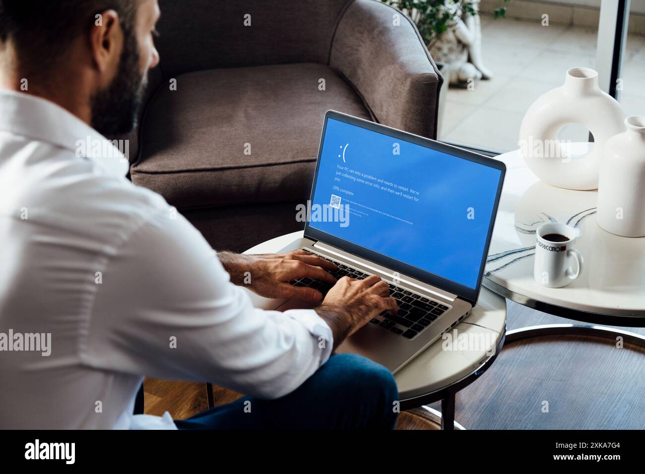 Uomo con notebook che mostra sullo schermo del monitor una schermata blu della morte o BSOD. Sistema operativo Microsoft Windows 10 difettoso. Rosario, Argentina - 19 luglio Foto Stock