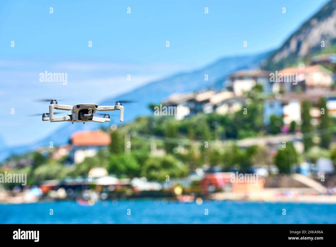 Malcesine, Lago di Garda, Italia - 20 luglio 2024: Un drone DJI Mini 4K si libra sull'acqua in vacanza sul Lago di Garda. Leggi e regole simboliche per le immagini dei droni con fotocamere all'estero *** Eine DJI Mini 4K Drohne schwebt über dem Wasser im Urlaub am Gardasee. Symbolbild Gesetze und Regeln für Drohnen mit Kamera im Ausland Foto Stock