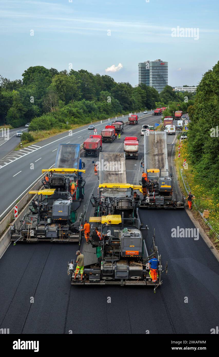 Essen, Nordrhein-Westfalen, Deutschland - Strassenbau, Asphaltfertiger und Strassenwalzen verbauen neuen, offenporigen, Fluesterasphalt auf der Autobahn A52, hier zwischen den Anschlussstellen Essen-Kettwig und Essen- Ruettenscheid in Fahrtrichtung Dortmund. Hinten Skyline von Essen mit dem Gebäude der EON Hauptverwaltung. Essen Nordrhein-Westfalen Deutschland *** Essen, Renania settentrionale-Vestfalia, Germania costruzione di strade, asfaltatrici e rulli stradali che costruiscono nuovo asfalto fluestere a pori aperti sull'autostrada A52, qui tra gli svincoli Essen Kettwig ed Essen Ruettenscheid in direzione Foto Stock