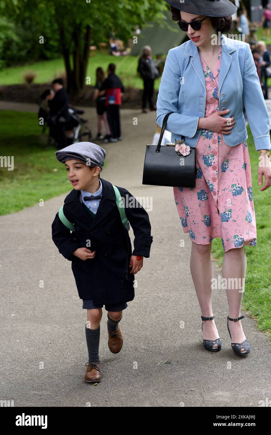 Donna e bambino vestite con costume del periodo degli anni '1940 al fine settimana di rievocazione della seconda Guerra Mondiale a Ironbridge, Shropshire, Regno Unito Foto Stock