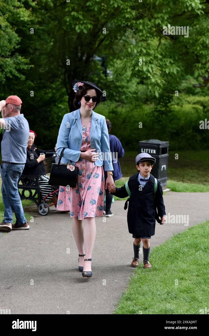 Donna e bambino vestite con costume del periodo degli anni '1940 al fine settimana di rievocazione della seconda Guerra Mondiale a Ironbridge, Shropshire, Regno Unito Foto Stock