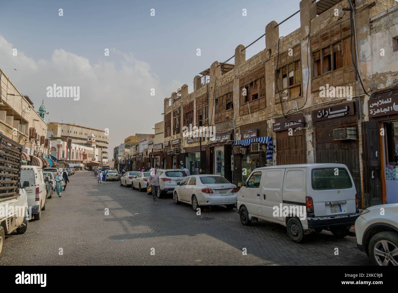 La strada trafficata nel centro storico di Jeddah, in Arabia Saudita, con negozi, automobili e persone locali che vivono nel quartiere di al Balad. Foto Stock