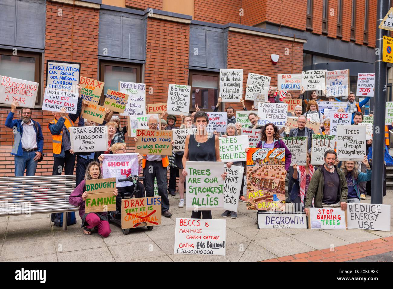 Leeds, Regno Unito. 22 LUGLIO 2024. Numerosi attivisti stanno con cartelli fuori dalla Corte Corona di Leeds a seguito della condanna dell'attivista di Axe Drax Karen 'Coffee' Wildin (centro) riguardo alla loro parte in una protesta in cui un treno verso la Drax powerstation è stato fermato. All'attivista è stato concesso un discarico condizionale e ha dovuto pagare le tasse del tribunale. Credito Milo Chandler/Alamy Live News Foto Stock