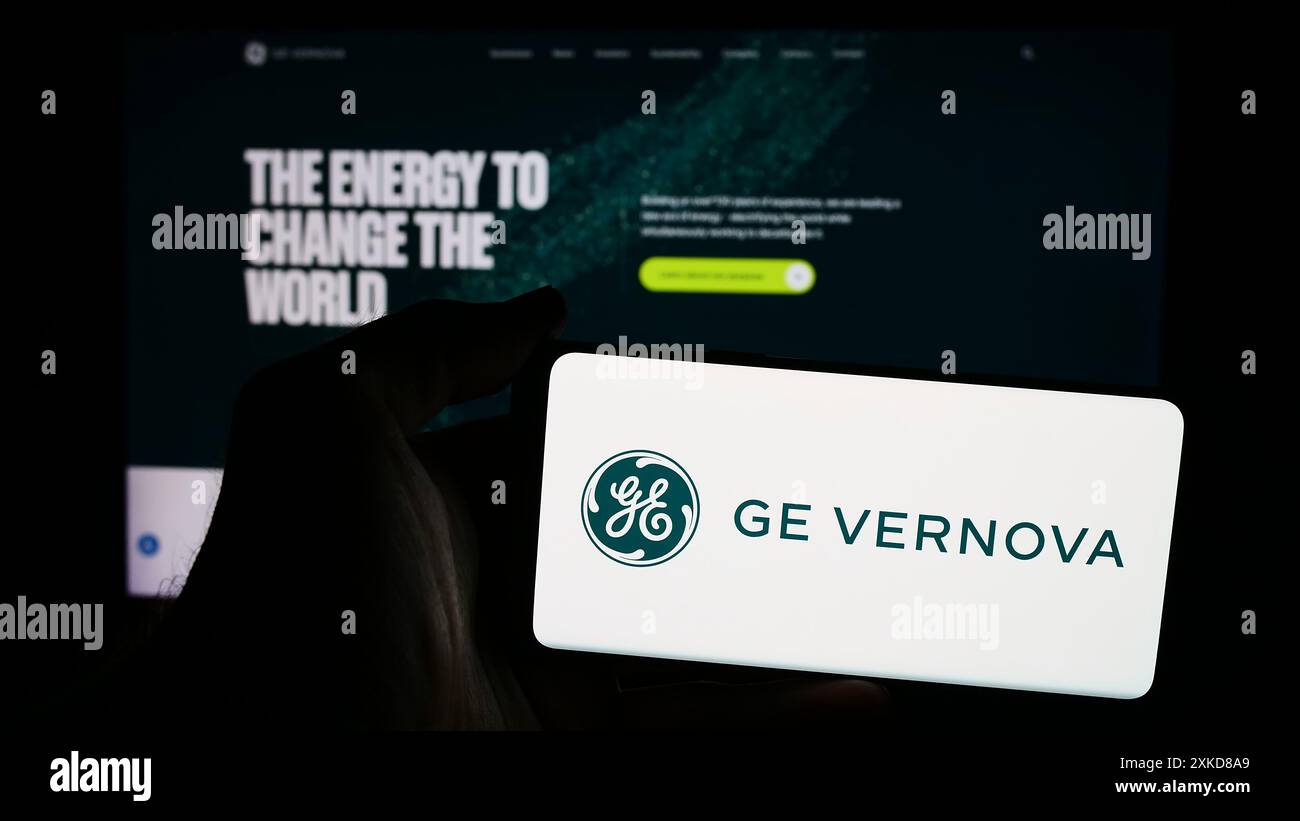 Persona che possiede uno smartphone con il logo della società statunitense di apparecchiature energetiche GE Vernova Inc. Davanti al sito Web. Mettere a fuoco il display del telefono. Foto Stock