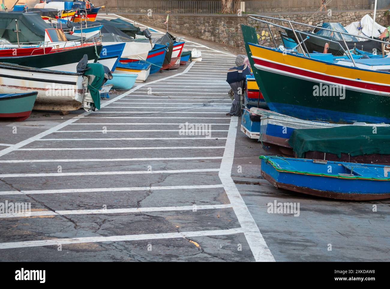 Cammina tra le colorate barche da pesca in legno a terra. Camara de Lobos, Madeira, Portogallo. Foto Stock
