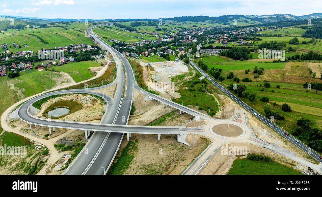 Nuovo frammento di autostrada in costruzione sulla strada Zakopianka, Polonia, sopra il villaggio di Klikuszowa. Rampe di ingresso e uscita, rotatoria. Stato a luglio Foto Stock