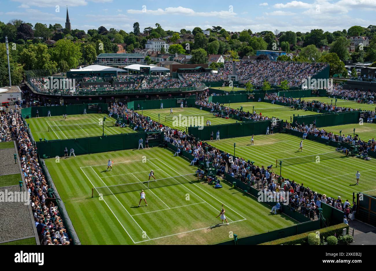 Una vista generale che si affaccia sui campi esterni meridionali con la guglia della chiesa di Santa Maria in lontananza ai Campionati 2024. Wimbledon Foto Stock