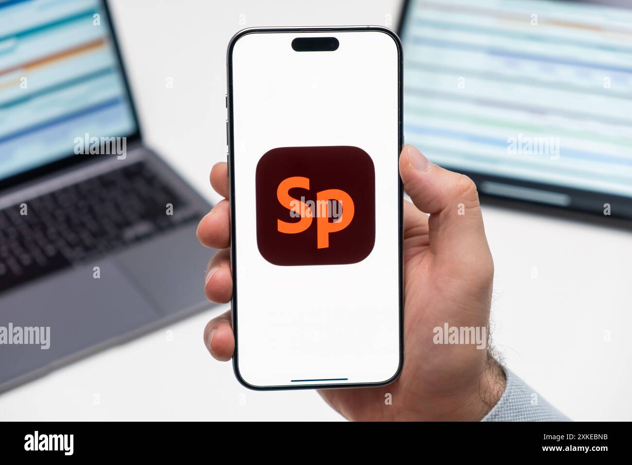 PRAGA, REPUBBLICA CECA - 21 GENNAIO 2024: Logo dell'icona Adobe Spark sullo schermo dello smartphone mans Hand sullo sfondo del luogo di lavoro. Foto Stock