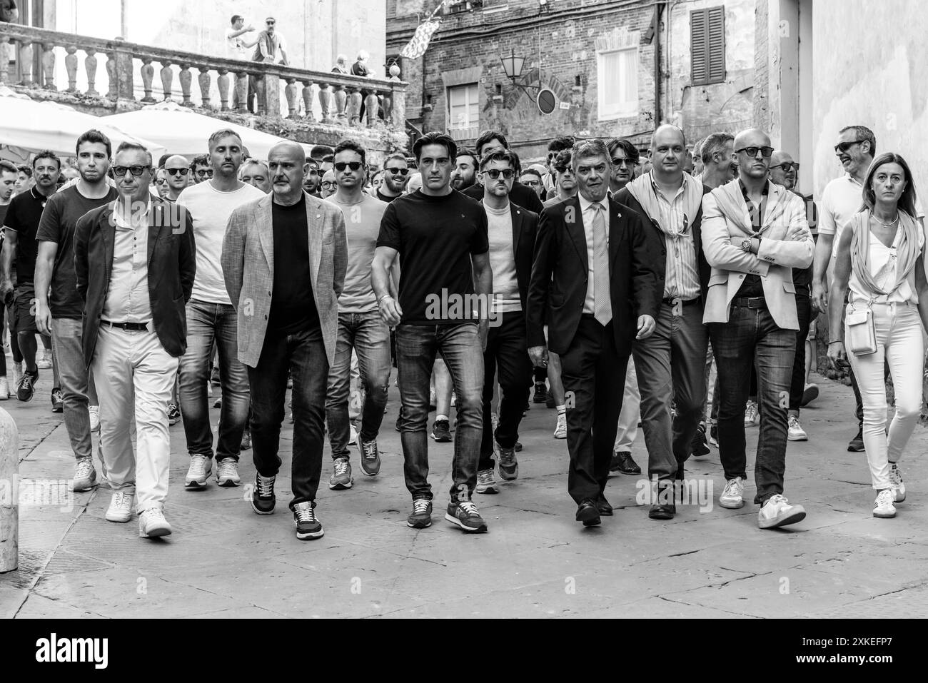 Le persone della Contrada Valdimontone accompagnano il loro Jockey (maglietta nera) alla Piazza per partecipare a Una gara di prova, il Palio, Siena, Italia. Foto Stock