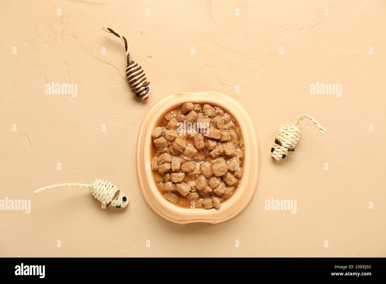 Ciotola di pappe bagnate e topi giocattolo su sfondo colorato Foto Stock