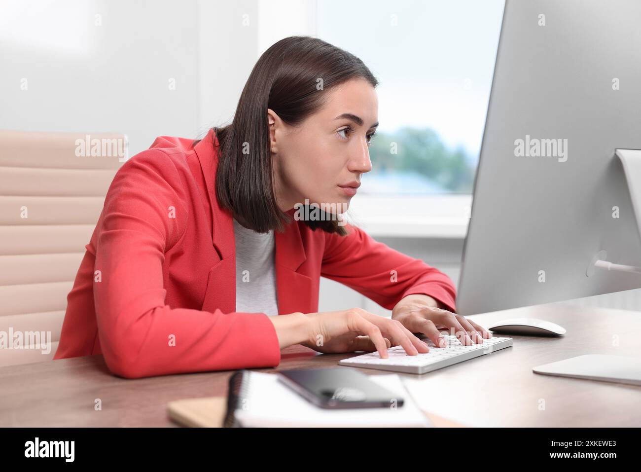 Donna con postura scarsa che lavora in ufficio Foto Stock