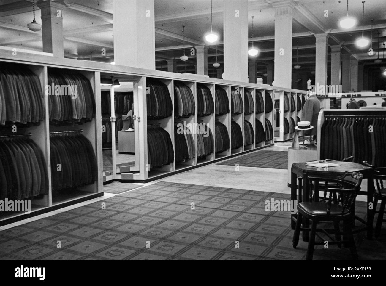 Oakland, California c. 1948 l'interno del negozio di abbigliamento maschile Athens Club presenta file di abiti. Foto Stock