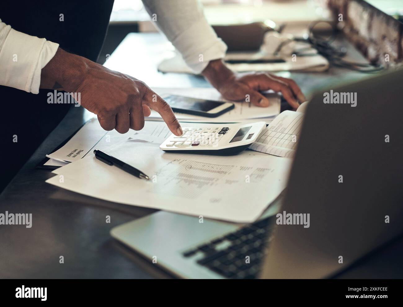 Barbiere, calcolatrice e uomo con documenti su laptop per la pianificazione finanziaria, il budget e la contabilità in salone. Cura dei capelli, piccole imprese e parrucchiere Foto Stock