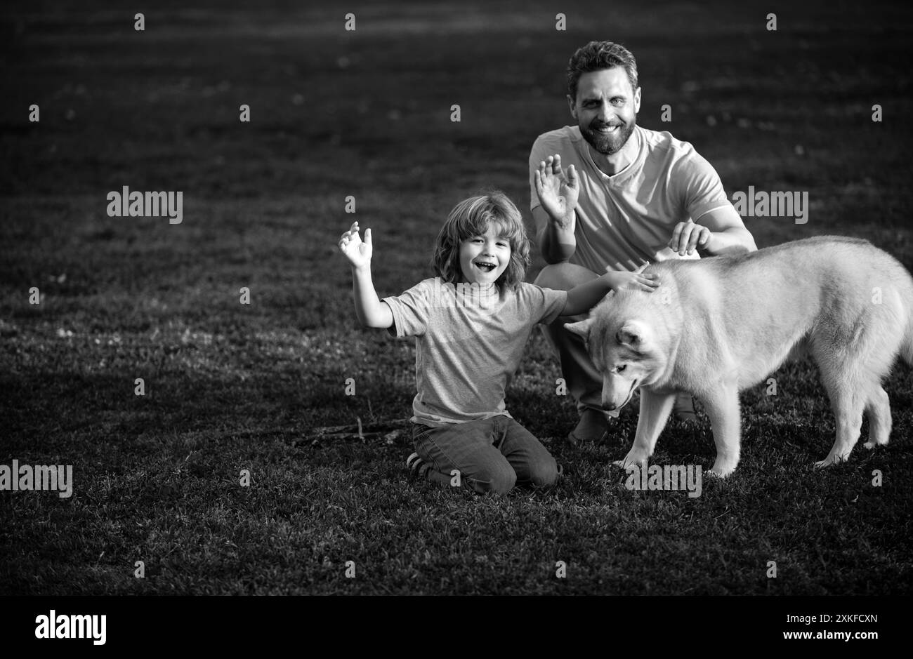 Felice padre e figlio con il cane al parco. Attività per il fine settimana, concetto di stile di vita familiare. Foto Stock