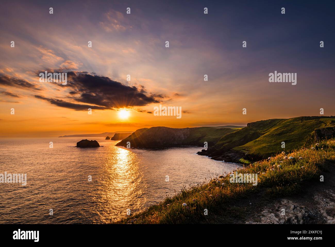 Alba vicino al solstizio d'estate che si innalza sulla baia di Gullastem, presa da Barras Nose, Tintagel, Cornovaglia, Regno Unito Foto Stock