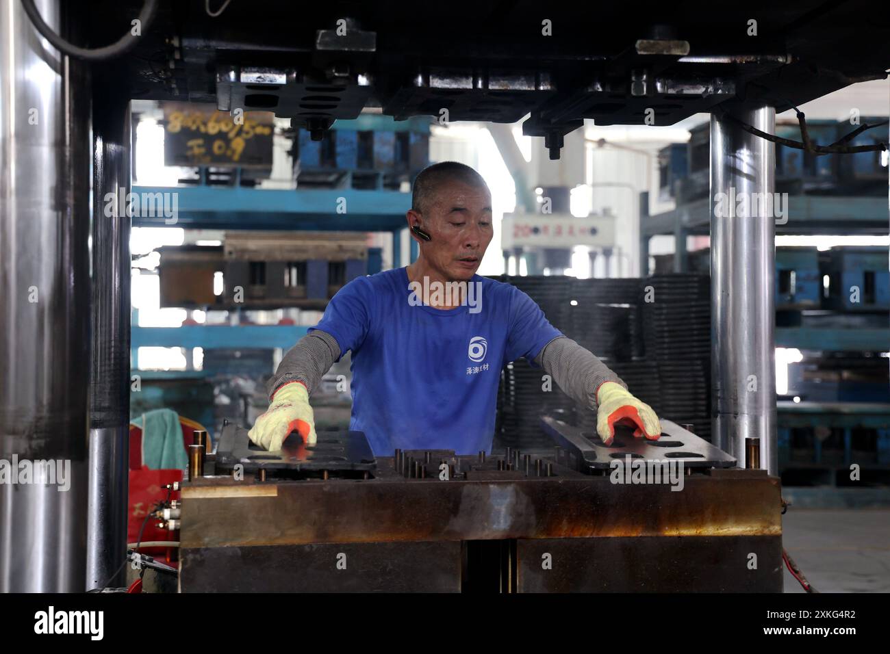 BINZHOU, CINA - 23 LUGLIO 2024 - Un lavoratore utilizza il fango rosso per lavorare materiali compositi polimerici in un'officina di un produttore di materiali compositi Foto Stock