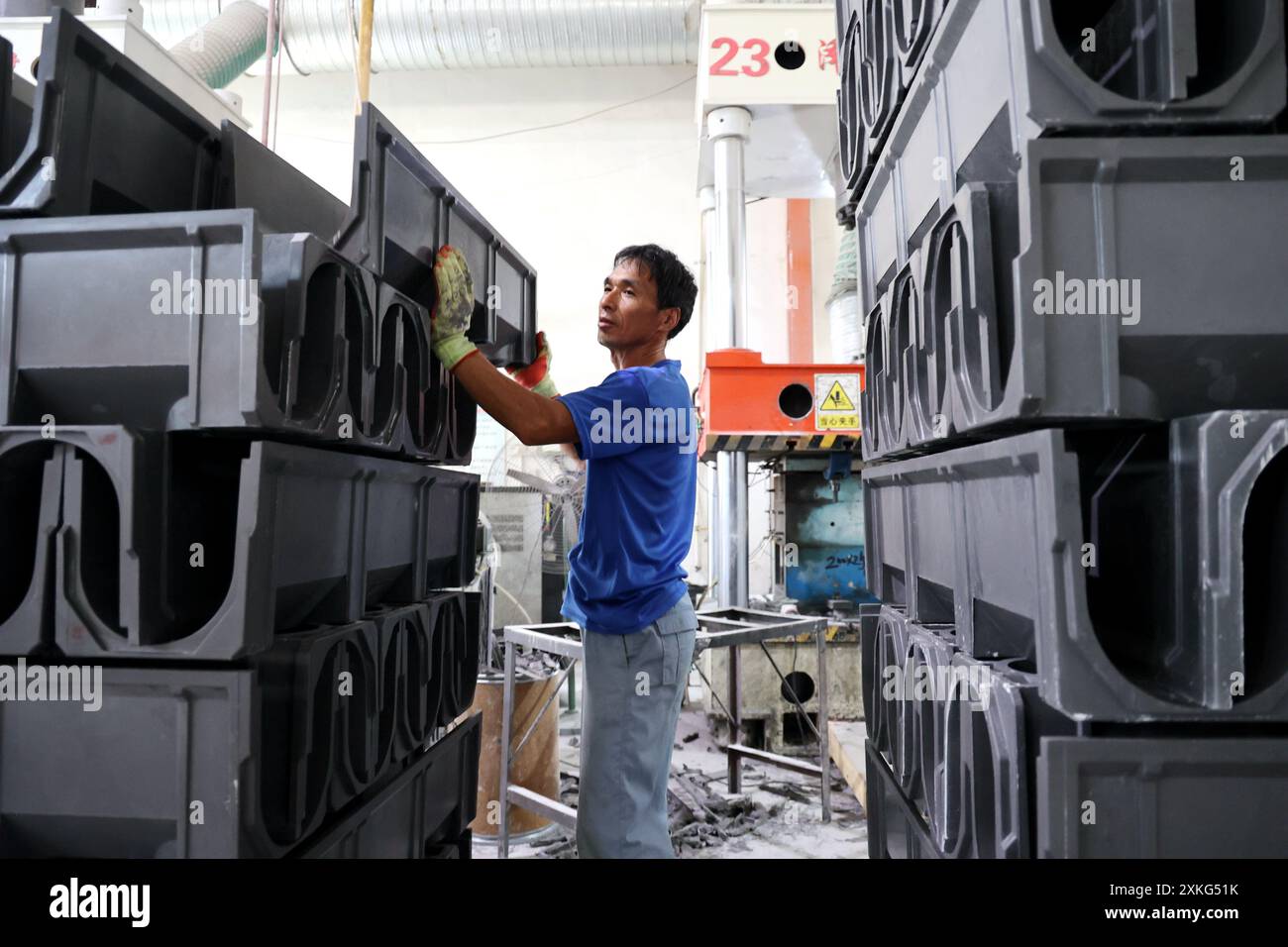 BINZHOU, CINA - 23 LUGLIO 2024 - Un lavoratore utilizza il fango rosso per lavorare materiali compositi polimerici in un'officina di un produttore di materiali compositi Foto Stock