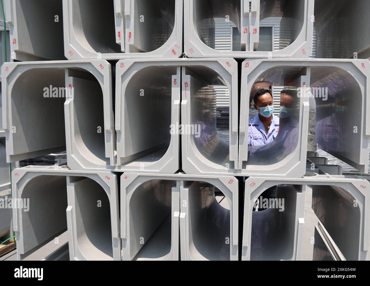 BINZHOU, CINA - 23 LUGLIO 2024 - Un lavoratore utilizza il fango rosso per lavorare materiali compositi polimerici in un'officina di un produttore di materiali compositi Foto Stock