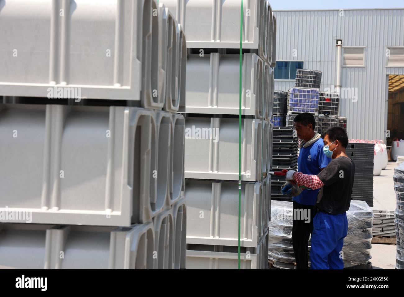 BINZHOU, CINA - 23 LUGLIO 2024 - Un lavoratore utilizza il fango rosso per lavorare materiali compositi polimerici in un'officina di un produttore di materiali compositi Foto Stock