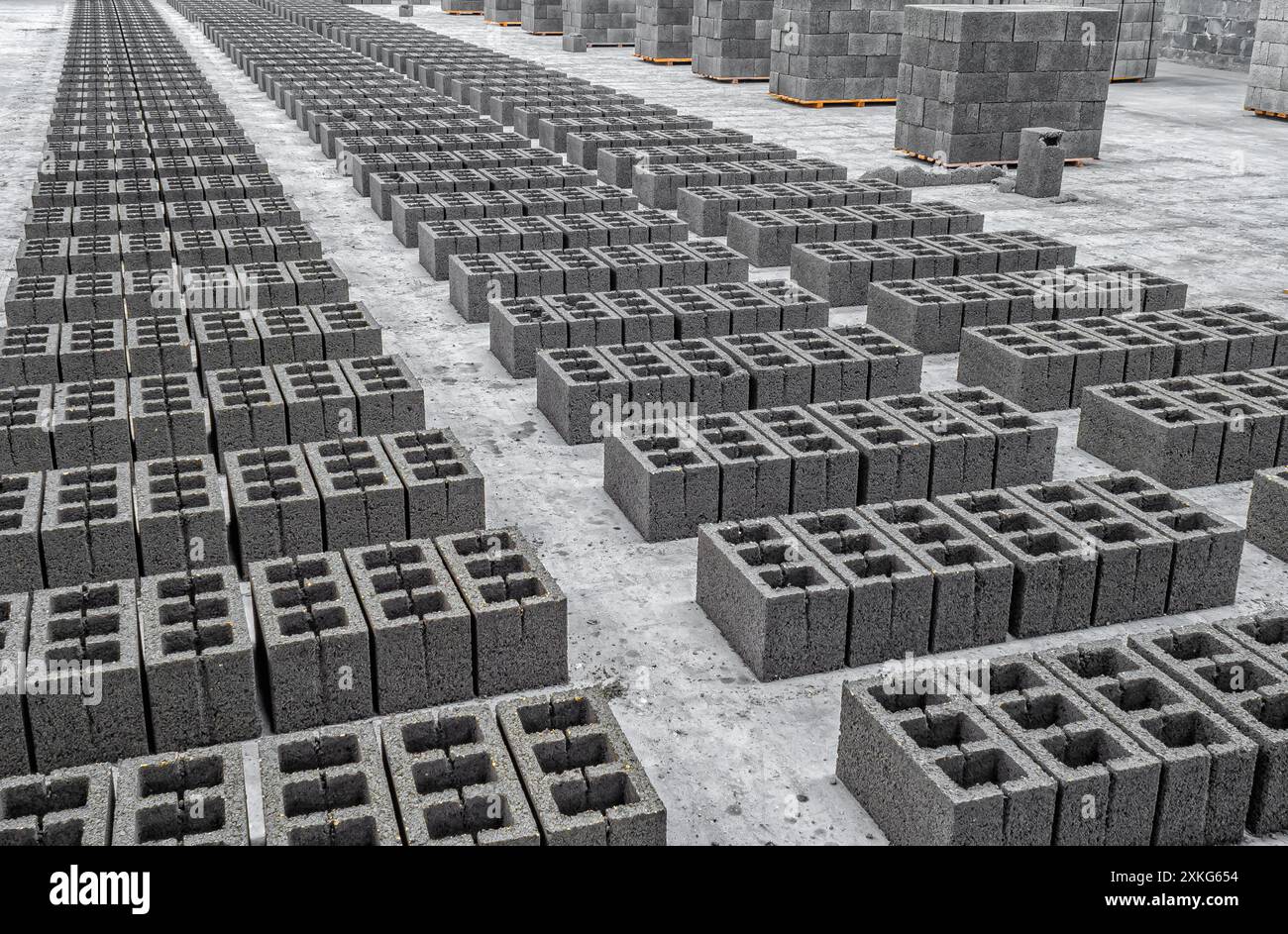 Vista dei blocchi di scorie in calcestruzzo, materiale da costruzione in forma di mattoni grigi. Produzione in fabbrica Foto Stock