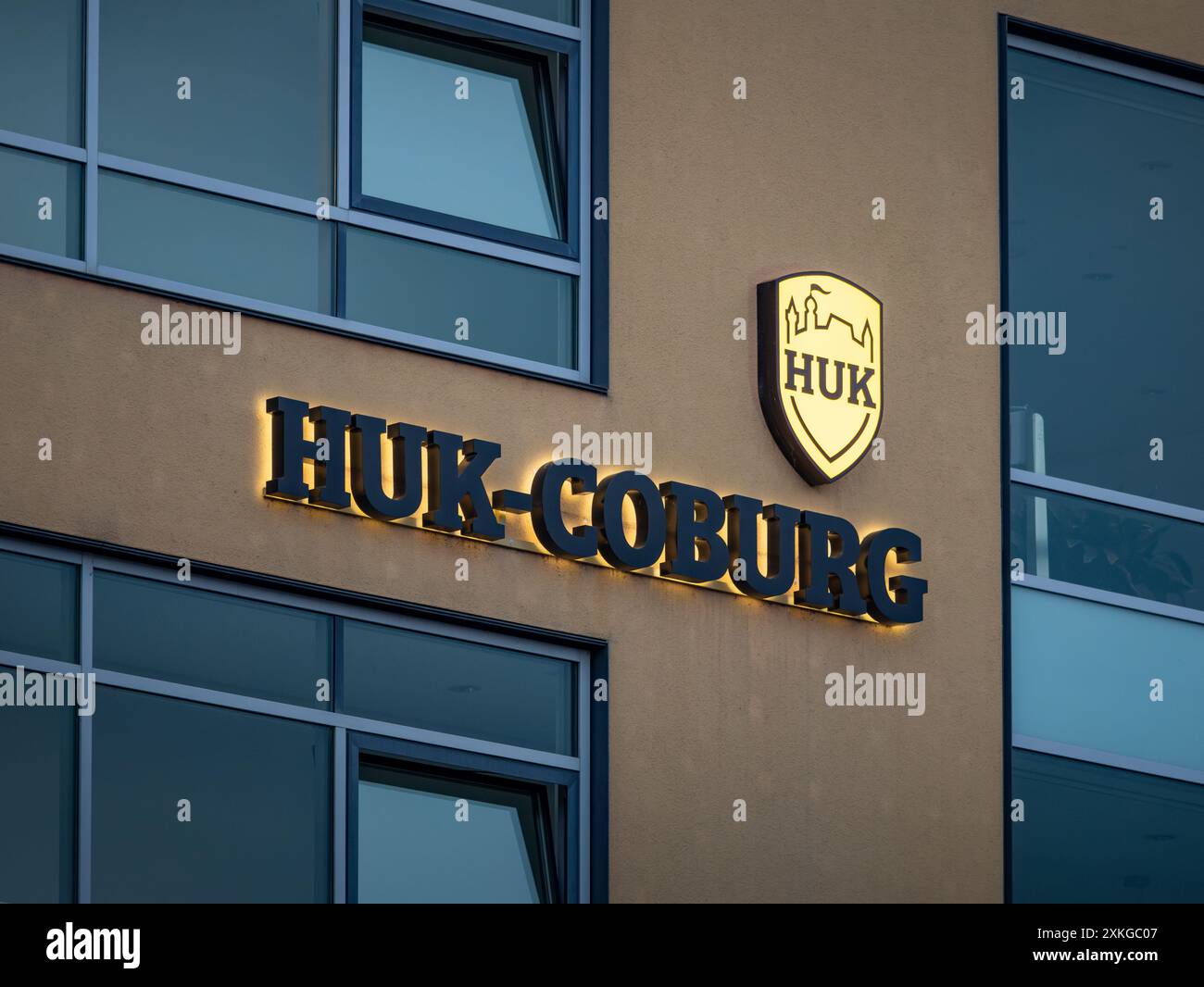 Logo HUK-Coburg segno della grande compagnia di assicurazioni tedesca. Logotipo illuminato sulla parete di un edificio di uffici. Fornitore di assicurazioni per responsabilità civile. Foto Stock