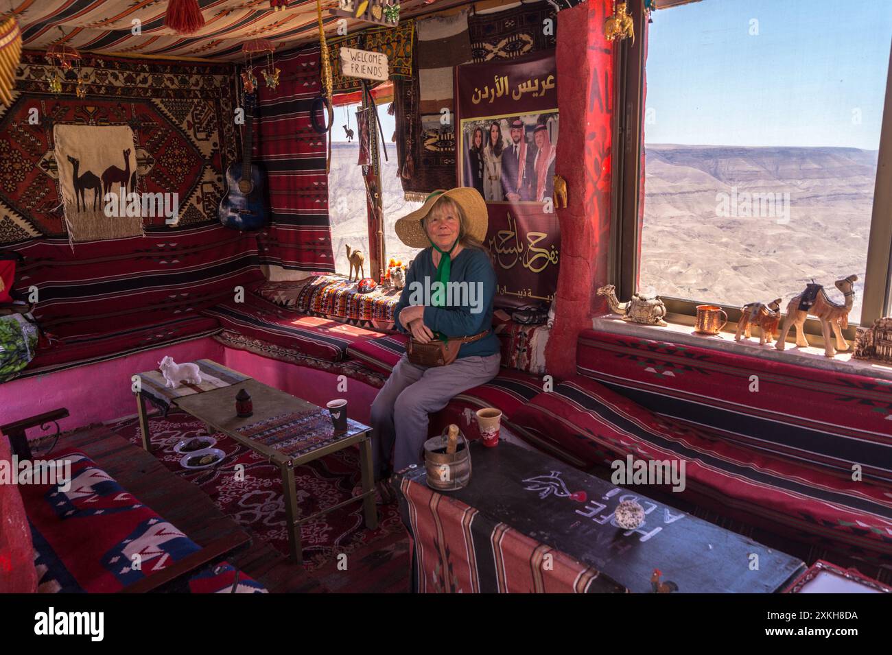 Una donna che beve un caffè turco all'interno della caffetteria beduina Aldi e un chiosco di souvenir al Moujib Panorama vicino a Wadi Mujib, in Giordania Foto Stock