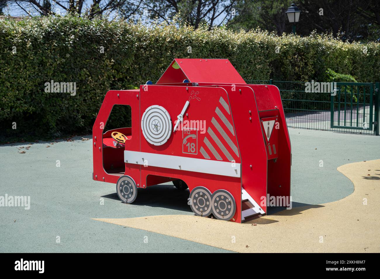 Scivolata di un motore antincendio rosso in un parco giochi per bambini, provenzale, Francia. Foto Stock