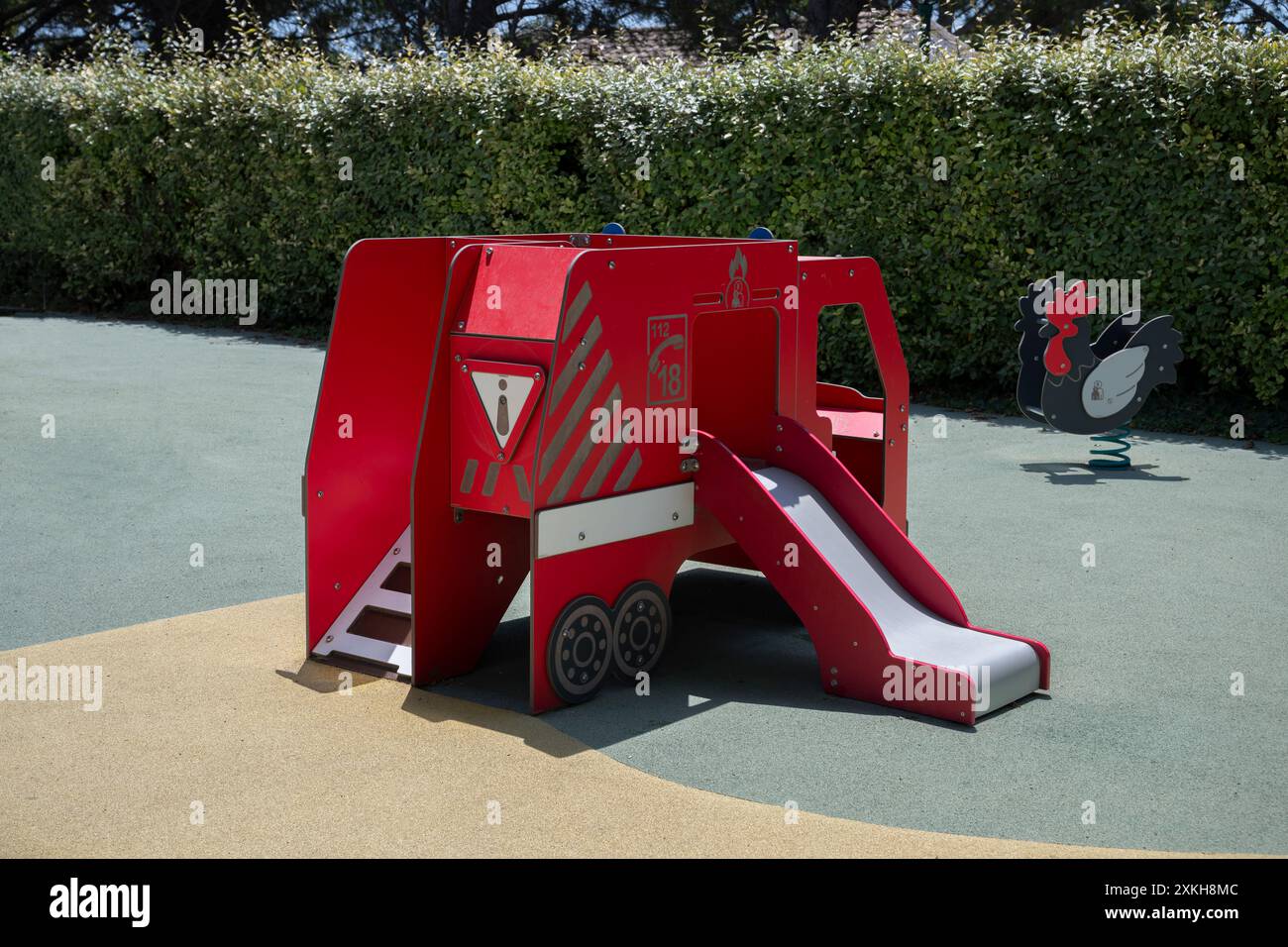 Scivolata di un motore antincendio rosso in un parco giochi per bambini, provenzale, Francia. Foto Stock