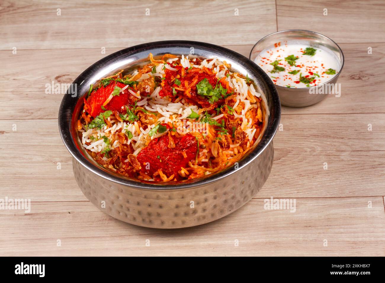 Tradizionale dum biryani di pollo con verdure miste servite con raita mista, concentrazione selettiva Foto Stock