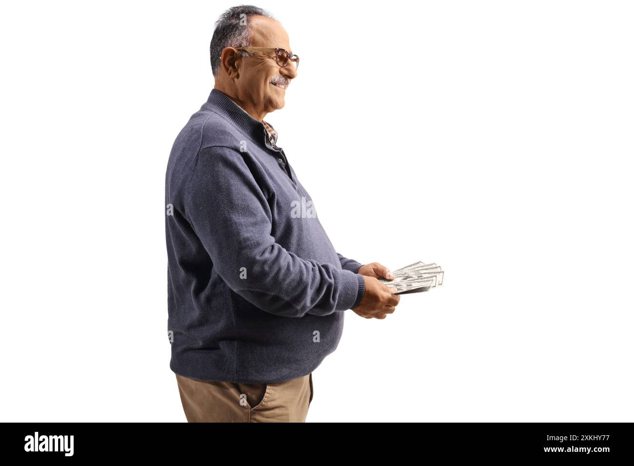 Foto del profilo di un uomo maturo che tiene i soldi isolati su sfondo bianco Foto Stock