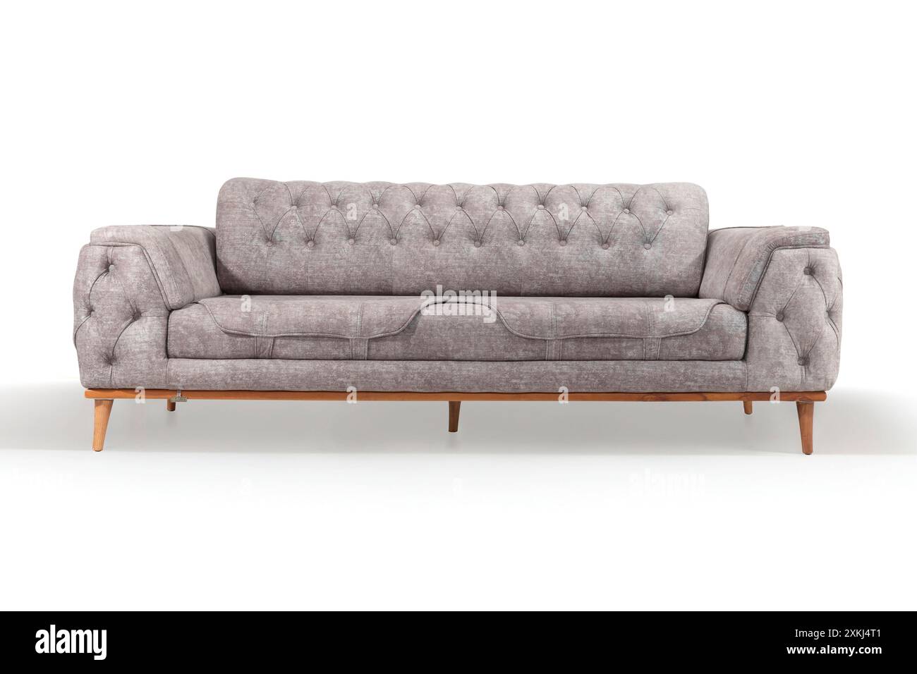 Elegante divano grigio con dettagli trapuntati, perfetto per un arredamento sofisticato in salotto. Foto Stock