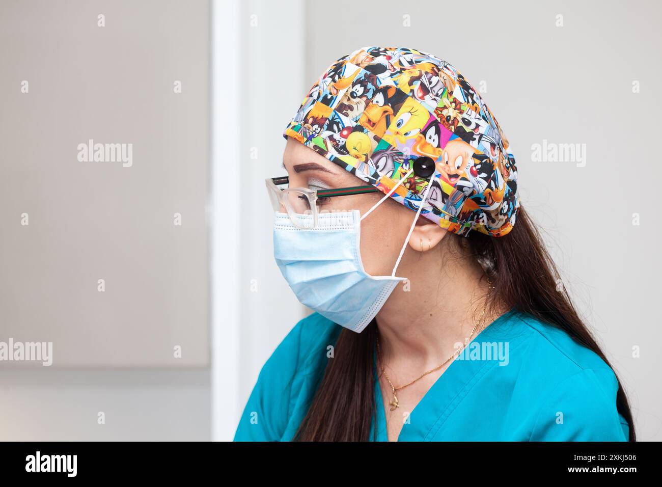 Assistente medico presso l'ufficio medico durante una procedura di rimozione della lesione cutanea. Foto Stock