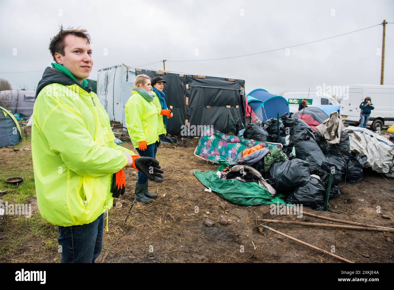 Pulisci spazzatura tre volontari che puliscono la spazzatura assemblata, nella giungla, un campo per migranti illegali, diretti verso il Regno Unito. Calais, Francia. Calais The Jungle Nord pas de Calais Francia Copyright: XGuidoxKoppesxPhotox Foto Stock