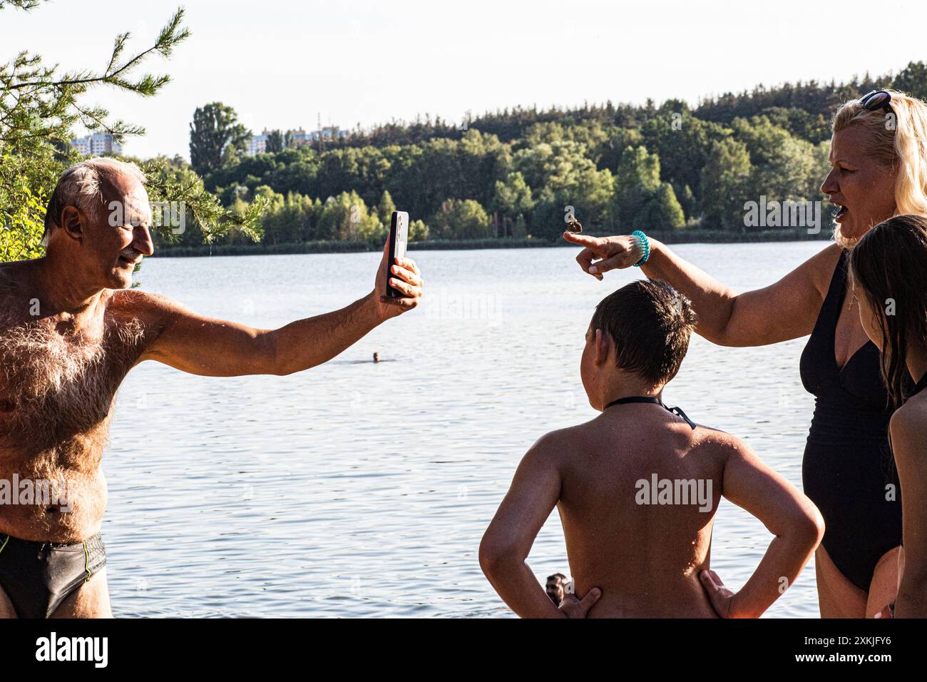 Una sessione fotografica di famiglia sulla spiaggia del lago Ministerka a Kiev con farfalla Foto Stock