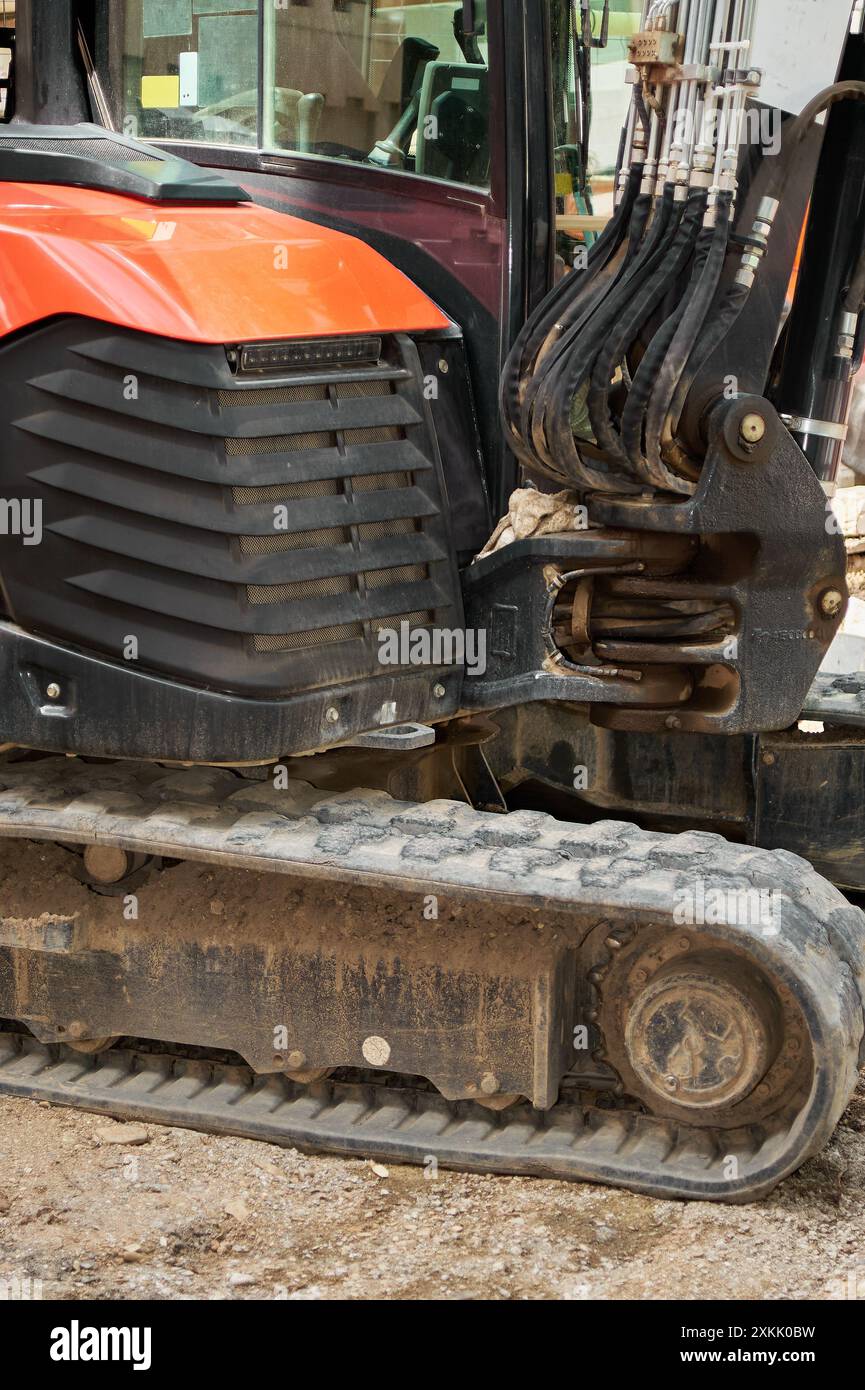 Immagine dettagliata di un escavatore in un cantiere, che mostra il braccio idraulico e i cingoli su di esso. Perfetto per gli argomenti relativi alla progettazione e al const Foto Stock