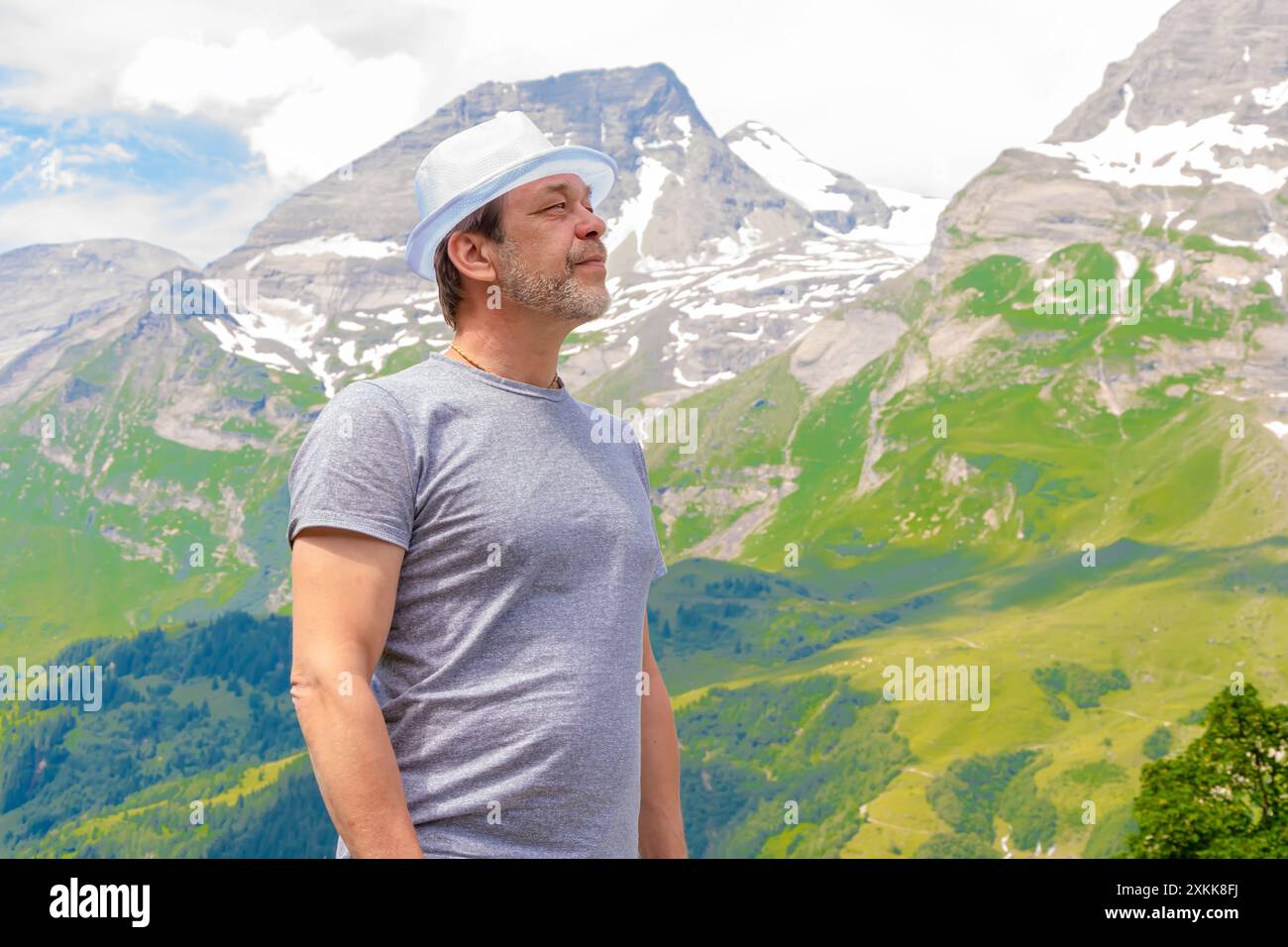 Ritratto di un anziano in un cappello bianco sullo sfondo delle montagne alpine Foto Stock