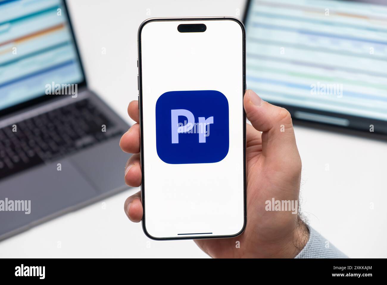 PRAGA, REPUBBLICA CECA - 21 GENNAIO 2024: Logo Adobe Premiere Pro CCAdobe Premiere Pro CCAdobe Premiere Pro CC sullo schermo dello smartphone a mans sullo sfondo del luogo di lavoro. Foto Stock