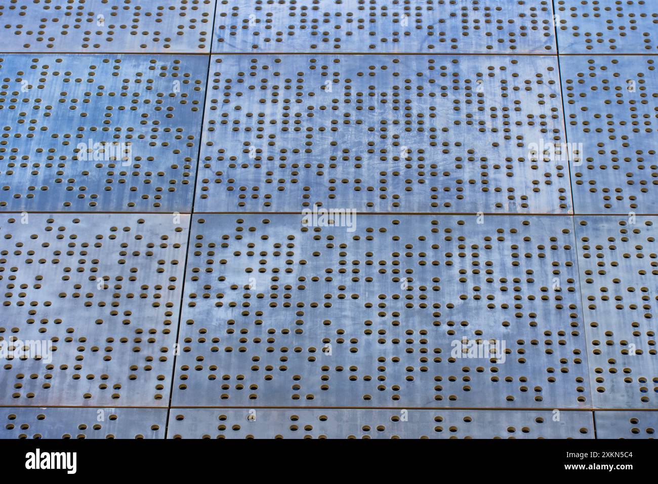 Vista ravvicinata di un intricato pavimento in metallo perforato, che enfatizza i motivi eleganti e mette in risalto l'estetica industriale moderna nell'architettura Foto Stock