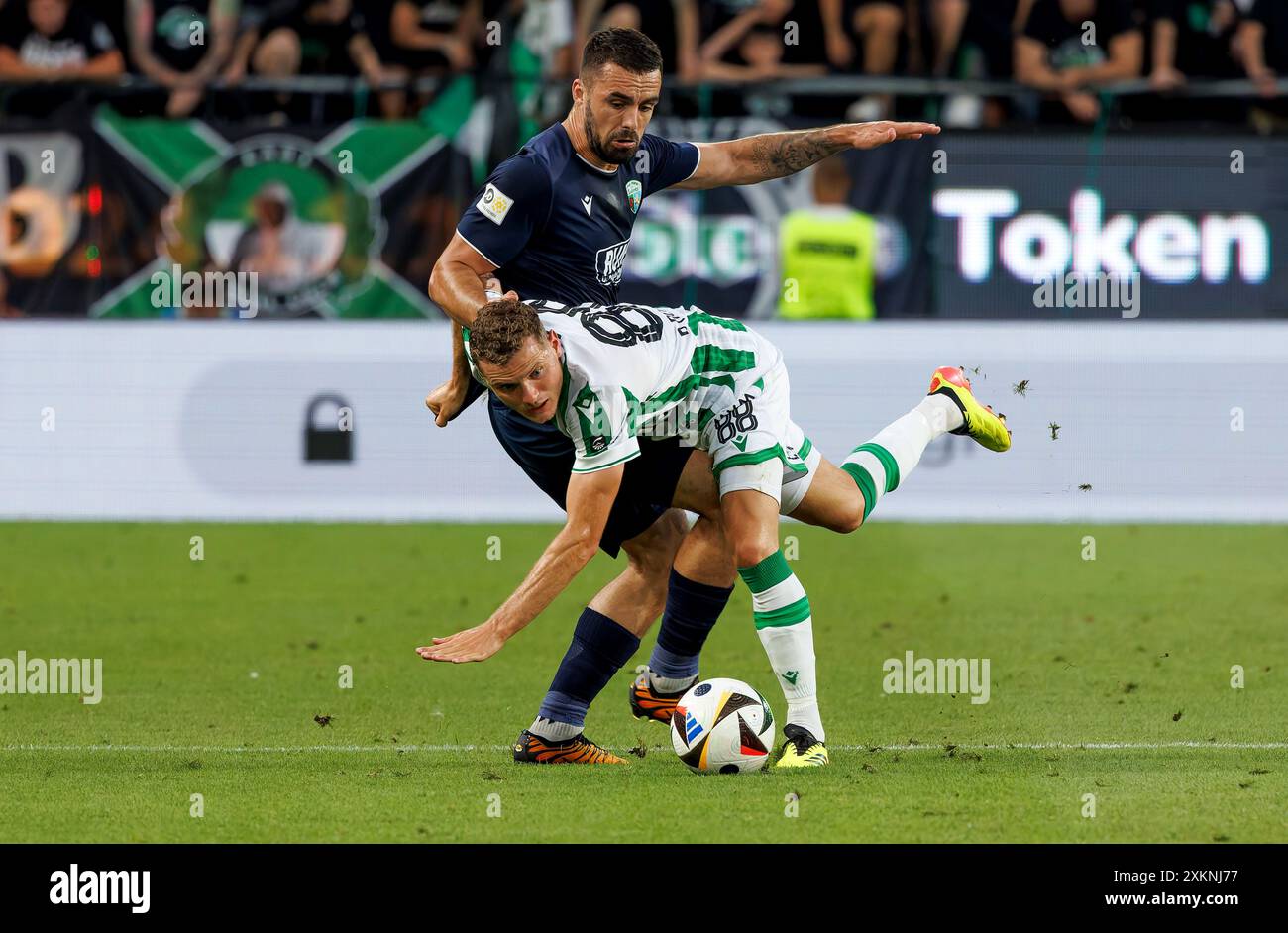 Budapest, Ungheria. 23 luglio 2024. Philippe Rommens di Ferencvarosi TC combatte per il possesso con Leo Smith dei New Saints FC durante la partita di qualificazione al secondo turno di qualificazione della UEFA Champions League 1a tappa tra Ferencvaros e i New Saints al Groupama Arena il 23 luglio 2024 a Budapest, Ungheria. Crediti: Laszlo Szirtesi/Alamy Live News Foto Stock