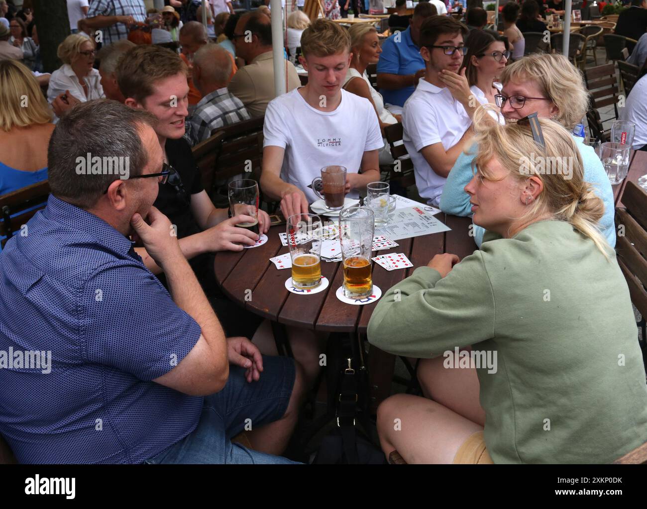 Cracovia. Cracovia. Polonia. Gruppo di turisti che bevono birra e giocano a carte nel giardino all'aperto. Foto Stock