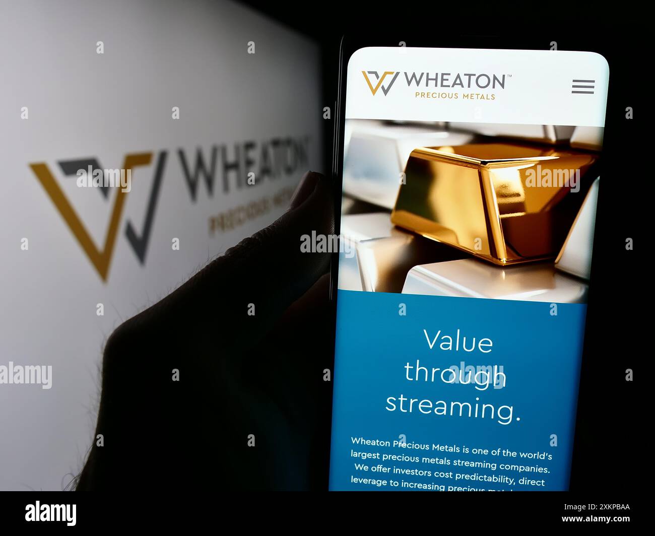 Persona che detiene lo smartphone con il sito Web della società canadese Wheaton Precious Metals Corp. Con il logo. Messa a fuoco al centro del display del telefono. Foto Stock