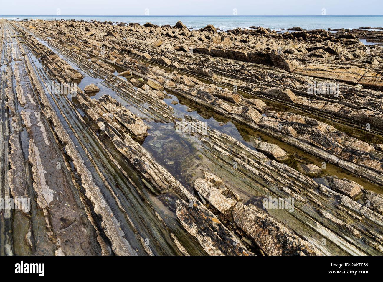 Serie di formazioni rocciose intervallate da acqua di mare e dall'Oceano Atlantico. Sakoneta Flysch, Deba, Gipuzkoa, Paesi Baschi, Spaiin. Foto Stock