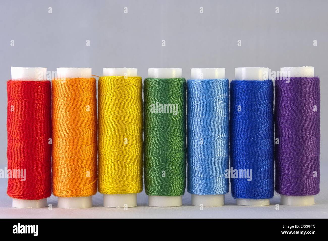 Fili da cucire di colore arcobaleno su sfondo bianco Foto Stock